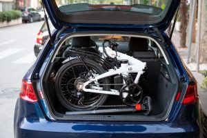 foldable bike placed into the back of a car in the city